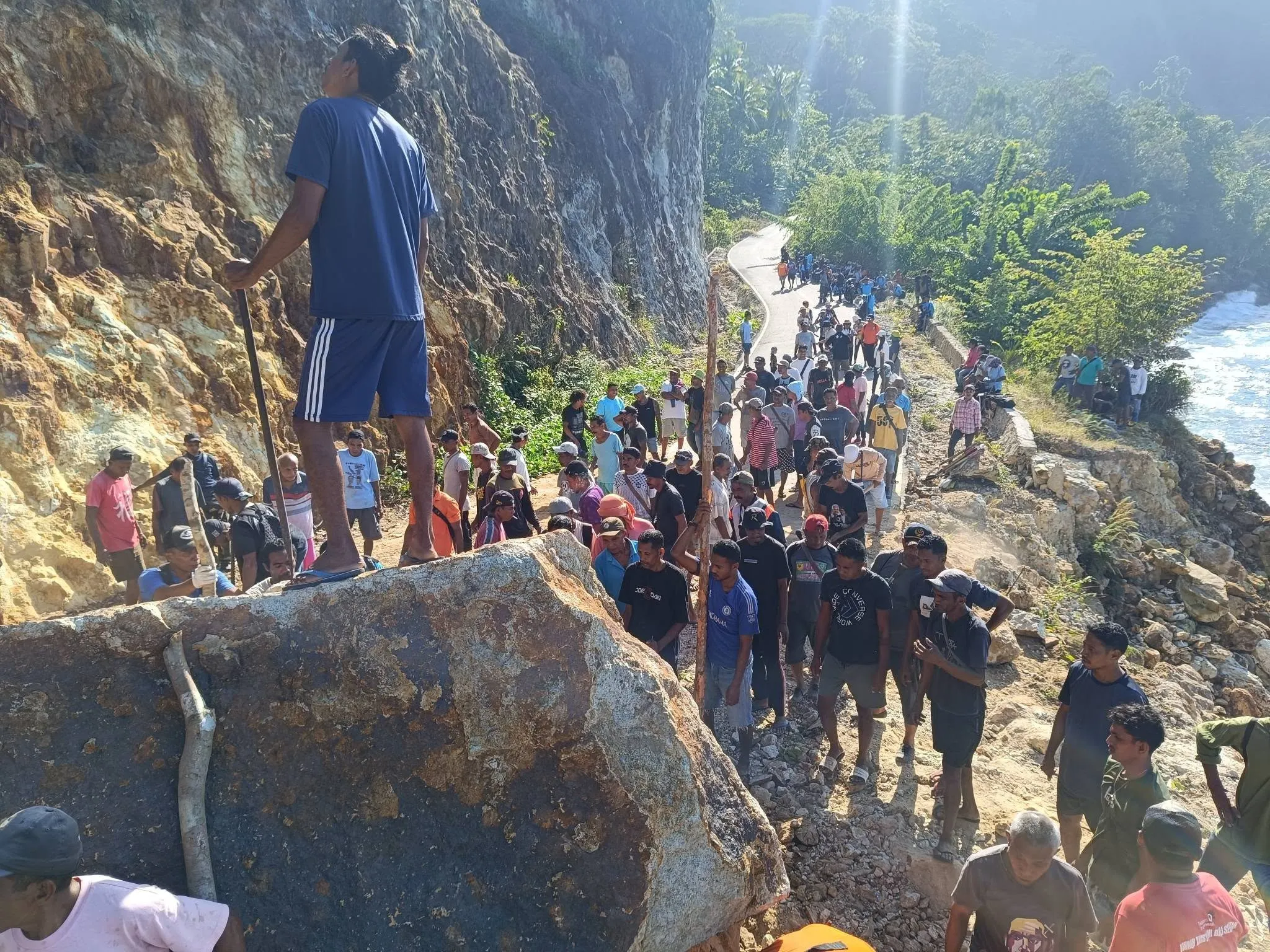 Warga berkumpul di ruas jalan pesisir yang terdampak longsor